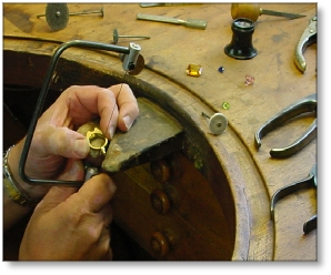 Formation en bijouterie: sciage d'un jet de fonte sur une bague.