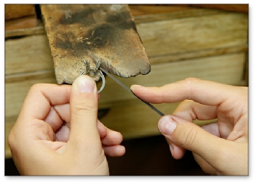 Formation en joaillerie: dernières retouche à la lime sur bague de joaillerie.